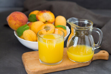 Apricots in a white plate in the background. Apricots on a wooden board. Dark background. copyspace