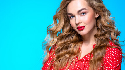 Portrait of a calm young blonde. Beautiful girl with long white hair. Model in a red shirt poses in...