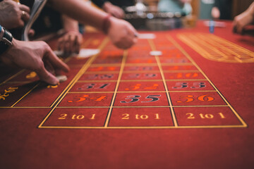 the roulette table, people make bets in the casino