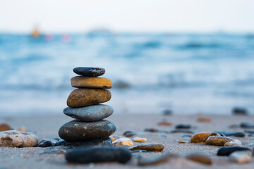 Pebbles are piled on a volcanic rock by the sea. Zen concept. Copy space