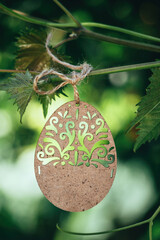 Easter card. Decorative wooden easter egg on spring garden background