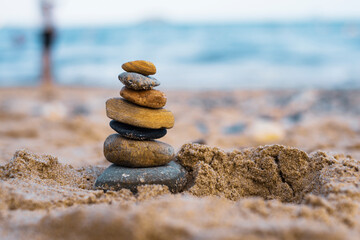 Pebbles are piled on a volcanic rock by the sea. Zen concept. Copy space