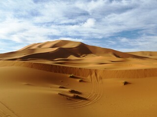 Fototapeta na wymiar Sand dunes of Erg Chebbi under blue sky with white clouds, Morocco