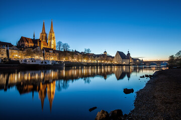 Fototapeta premium Regensburg mit spiegelung bei Niedrigwasser zur blauen Stunde