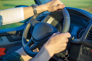 male hands on the steering wheel of a car