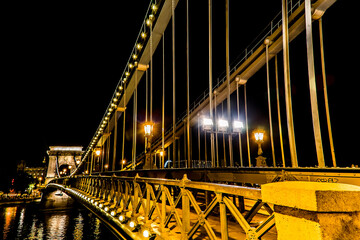 A view across the Chain Bridge across the River Danube in Budapest at night in the summertime