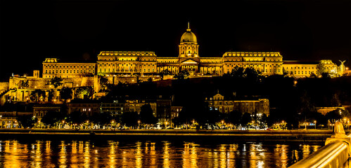 A view from the Chain Bridge across the River Danube in Budapest at night towards the Royal Palace in the summertime