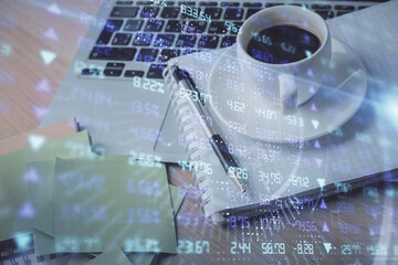 Double exposure of forex chart drawing and desktop with coffee and items on table background. Concept of financial market trading