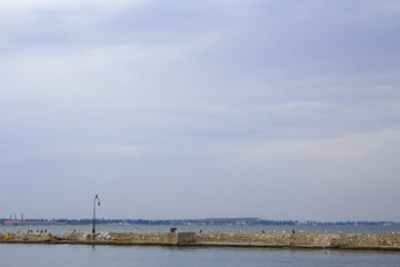 Dilapidated old fishing dock collapsing into the sea. Walking paths on the promenade. 