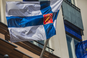 Waving flag of Finland and European Union flag hanging on the finnish institutions and administrative building in Helsinki, Uusimaa region