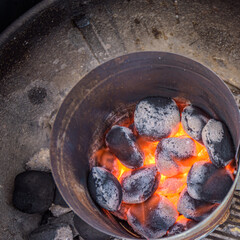 above view of flaming hot charcoal briquettes in a grill starter on a bbq