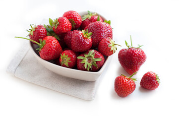 Breakfast with strawberries on white background. Breakfast for child. Strawberries in a white heart-shaped bowl