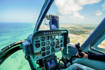Helicopter cabin inside cockpit aerial top view on blue sky and water at the caribbean coast and...