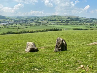 Landscape view from high ground, above, Eastby, with rocks, meadows and fields, and a village in...