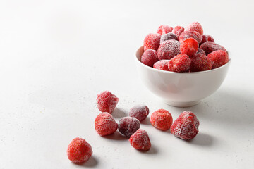 Frozen strawberries and cherry in bowl on white background. Copy space.