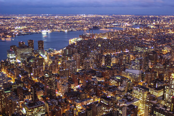 Illuminated New York skyline with skyscrapers seen from an aerial view