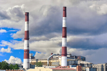 Fototapeta na wymiar Industrial factory with tall pipes on a blue sky. Environment concept.