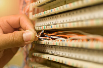 Man holding telephone wires in pbx telephone closet