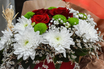 Flower arrangement of white petals and red roses