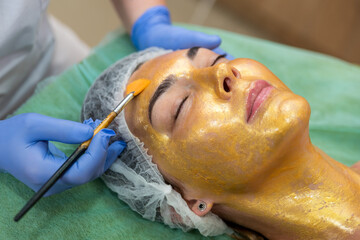 the client makes a procedure for the care of a mask of gold close-up