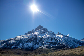 Sol sobre cume de montanha coberto de neve na Patagônia