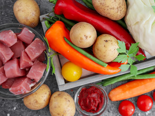 potatoes with meat and vegetables on a stone background, close-up top view.