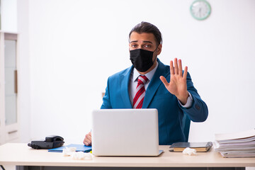 Sick male employee suffering at workplace from coronavirus