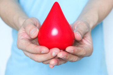 Hand of a healthy man hold symbol blood.Help and Health Concepts
