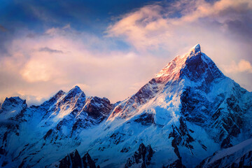 Majestical scene with mountains with snowy peaks in clouds in Nepal. Colorful landscape with beautiful high rocks and dramatic cloudy sky at sunset. Nature background. Fairy scene. Amazing mountains  - obrazy, fototapety, plakaty