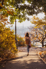 Beautiful woman walking in autumn park on Buda Castle on banks of Danube in Budapest, Hungary.