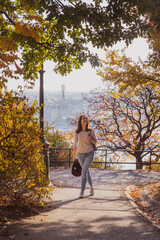 Beautiful woman walking in autumn park on Buda Castle on banks of Danube in Budapest, Hungary.