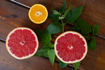 oranges and grapefruit on a brown wooden background, top view, text space, citrus