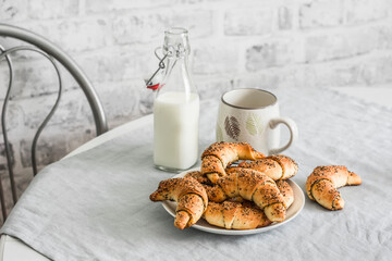 Poppy seeds croissants and a bottle of milk on the kitchen table. Delicious breakfast, snack
