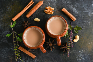 Top view of Indian Masala Chai or traditional beverage with tea, milk and spices Kerala India. Two...