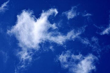 White cloud in the shape of a heart in the blue sky. Natural shape heart in the sky with clouds. Heart shaped cloud over blue sky./ Sky of love