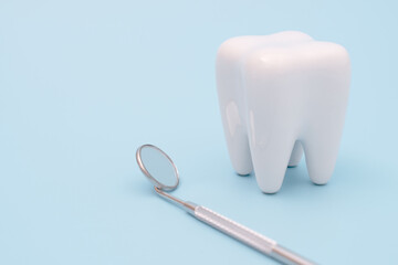 Teeth model and dentist tool on blue