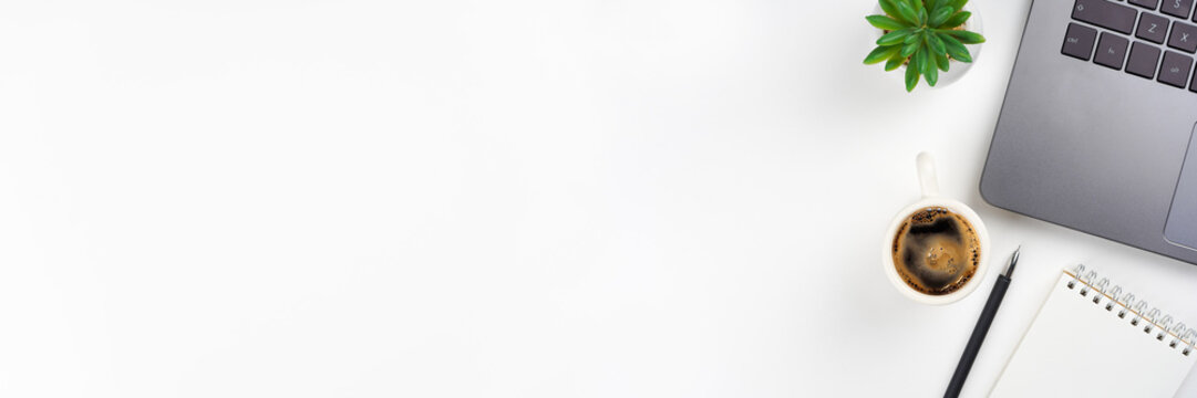 Laptop, coffee cup, plant, notebook, pen on white background. Workplace concept. Top view, copy space, flat lay, horizontal banner