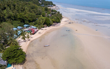Fototapeta na wymiar Aerial shoreline with fishing thai boats parking along the sand beach, Baan Tai area, koh Phangan island, Thailand