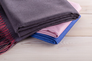  Several luxurious women's cashmere shawls, scarves in multi-colored colors. Elegant textile background in trendy colors.
