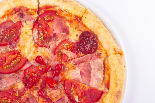 tasty pizza on a white plate with tomatoes and ham. italian food isolated on the white background