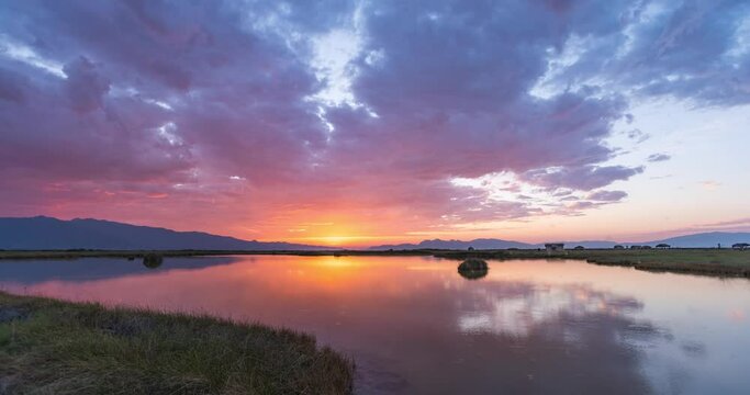 Time lapse of Cuatro Ci&eacute;negas swamp ecological reserve during a cloudy golden hour and sunrise. Lake as mirror of the sky full of color. Coahuila, Mexico