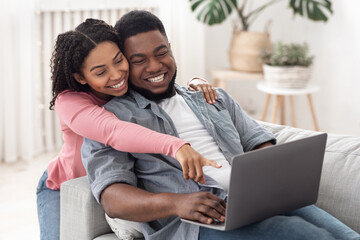 Online Shopping Concept. Black Couple Using Laptop At Home, Ordering In Internet
