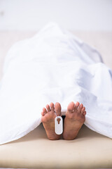 Police coroner examining dead body corpse in morgue