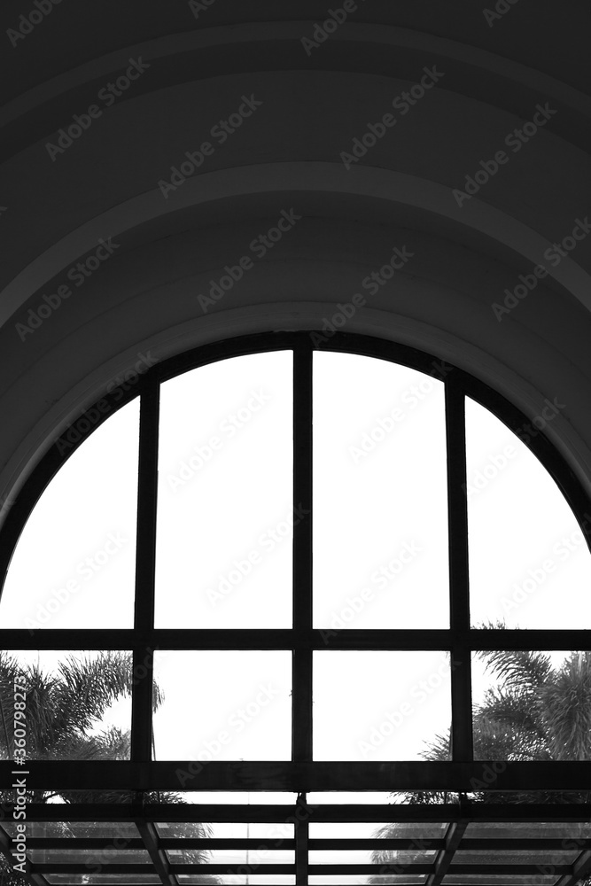 Sticker Vertical grayscale shot of an interior with a window arc