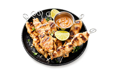Grilled chicken satay skewers with peanut butter sauce isolated on white background