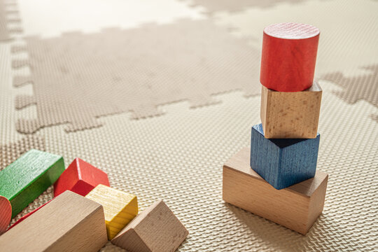 wooden building blocks on interlocking floor mat