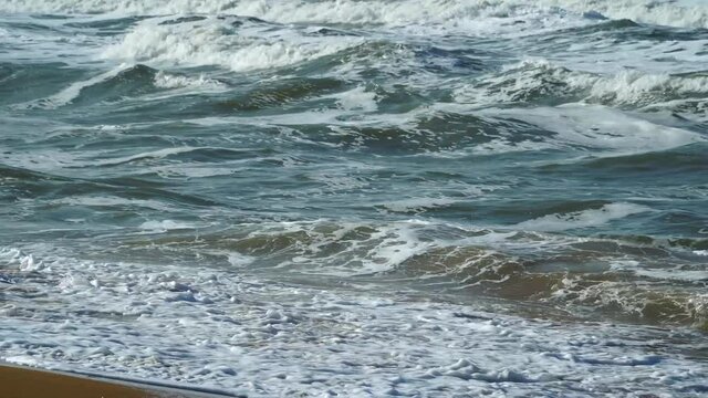 Rolling waves rushing to beach, brown sand and powerful waves, seascape, occean