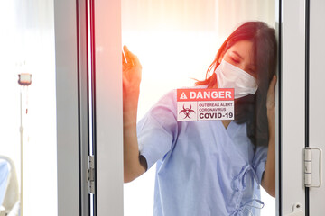 Alone woman wear face mask and standing worry or sadness about covid-19 quarantine in a hospital room, virus protection