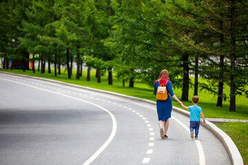 Mother and her son walking in the road