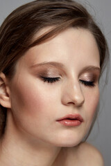 Fototapeta premium Cute everyday make-up in a young brunette girl. Eyes closed.